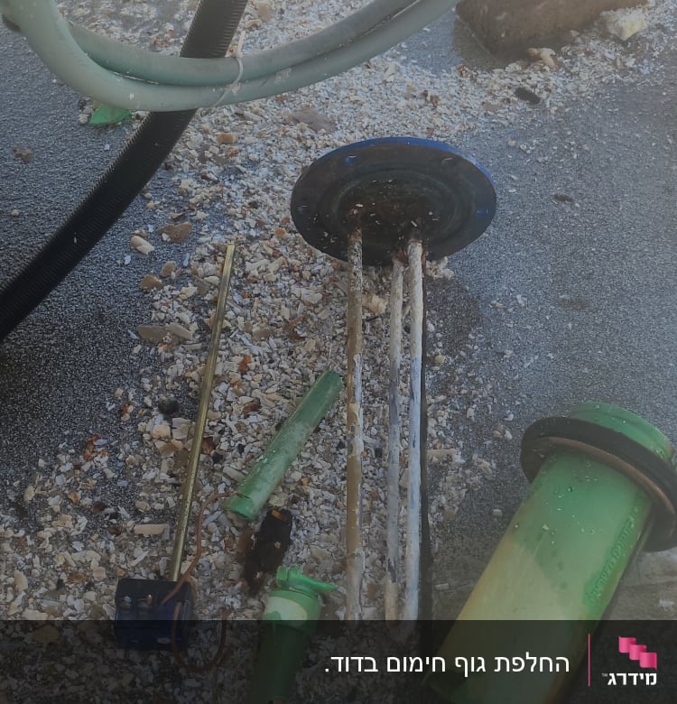 חלקי דוד שמש מפורקים על הקרקע עם צינורות וחלקים ירוקים